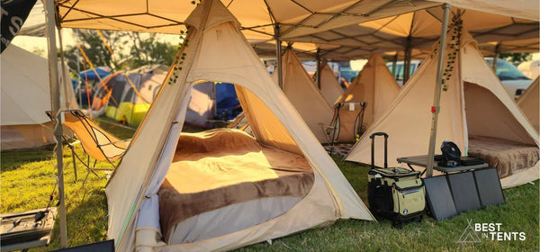 Luxury festival tent rentals with cozy beds, chairs, and luggage by Best in Tents.