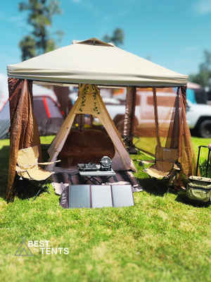 Luxury festival camping tent setup with chairs, solar panels, and Best in Tents logo outdoors
